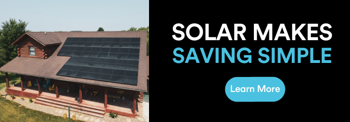 Next to a photo of a log cabin with solar installed on the roof, on a black background we see the words "solar makes saving simple" in white and bright blue text. Below the text is a bright blue button with white text that reads "learn more"