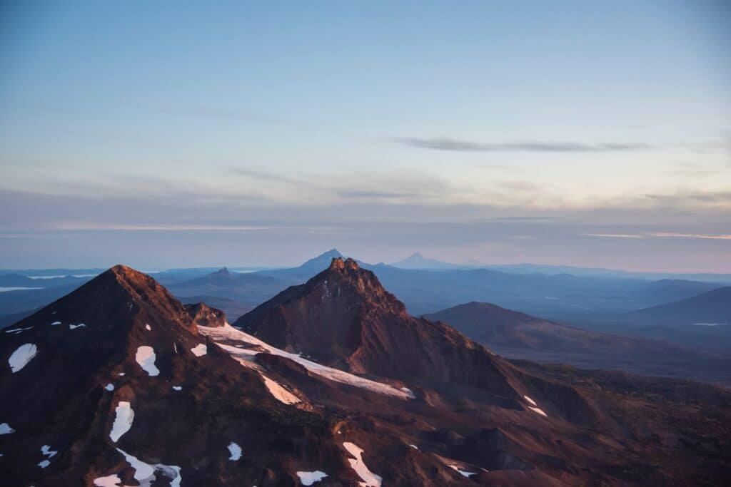 A landscape photo of a mountain range in Oregon peppered with snow.