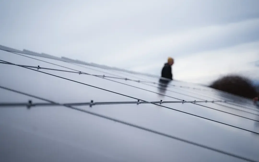 New cleaned solar panels with a solar tech installer in the background