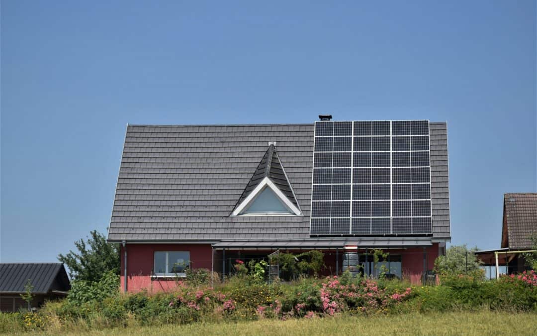 Solar Panels on top of a house against a blue sky.